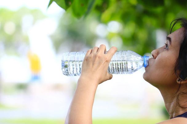 Stock Photo - Woman tired and drinking water after exercise. Wit - Φωτογραφία, εικόνα