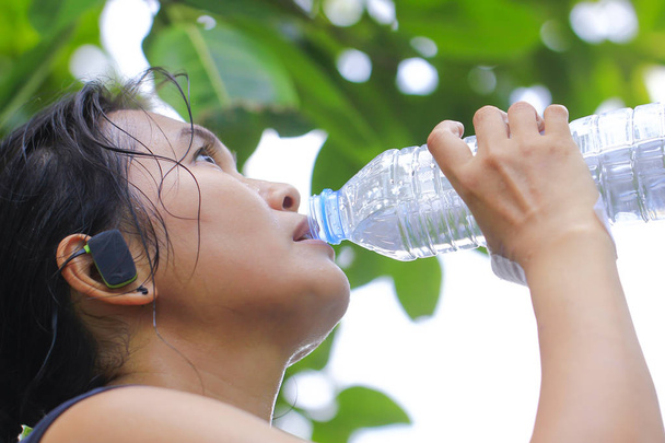 Foto de stock - Mujer cansada y bebiendo agua después del ejercicio. Ingenio.
 - Foto, imagen