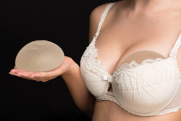 Young woman in beige compression bra bandage after breast augmentation  surgery mammoplasty. banner. advertising. copy space Stock Photo