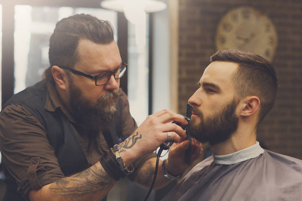 Чоловік зачісується перукарем у перукарні
 - Фото, зображення