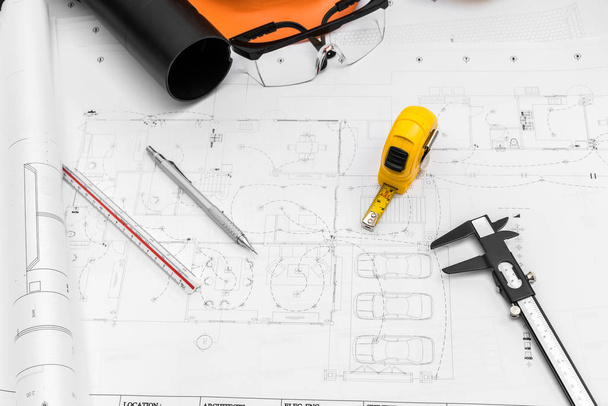 Planes de construcción con casco y herramientas de dibujo en planos
 - Foto, Imagen