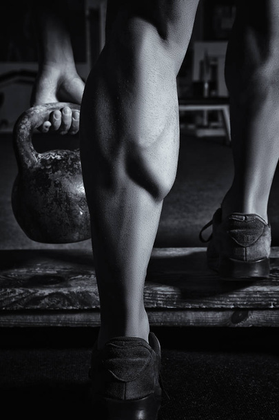 Close up of muscular bodybuilders leg doing exercises with weights - Valokuva, kuva