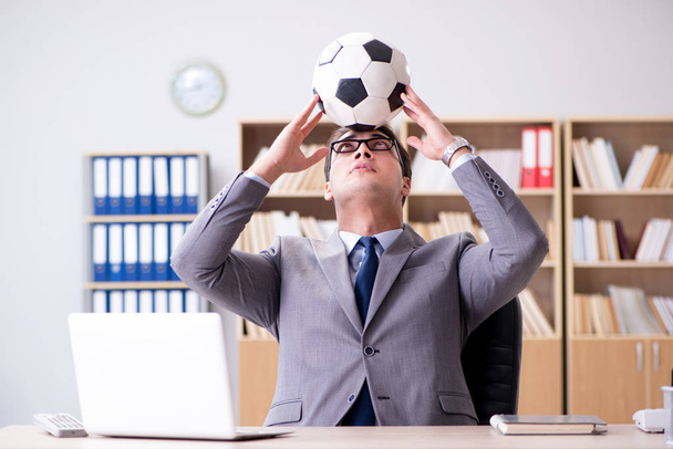 Businessman with football ball in office - Foto, afbeelding