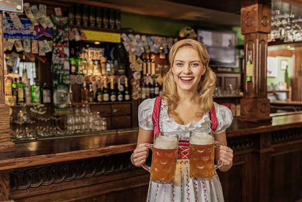 Outgoing woman carrying cups of beer - Photo, image