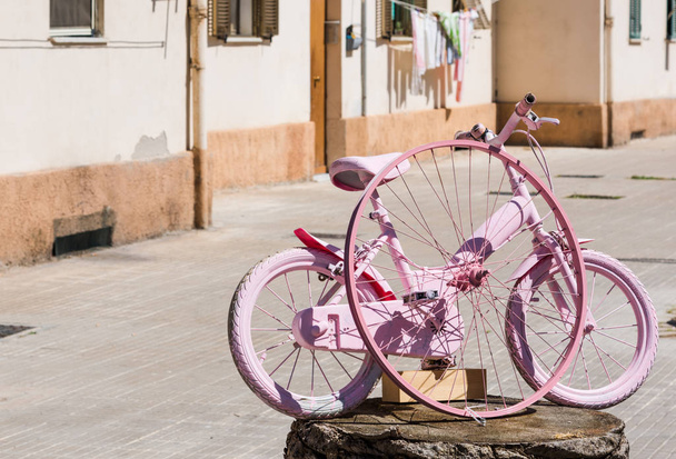 bicicleta pequena pintada em rosa em Alghero
 - Foto, Imagem