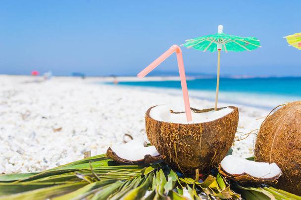 cocktail umbrellas and straw in a coconut - Photo, image