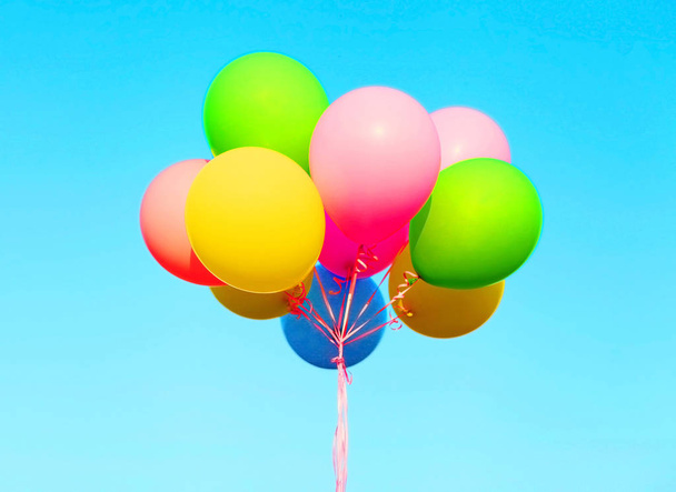 Colorful bundle of air balloons on a blue sky background - Foto, afbeelding