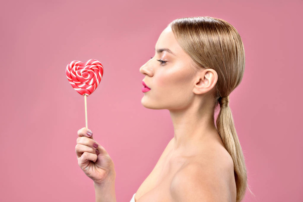 Pretty girl posing with color sweetmeat - Fotó, kép