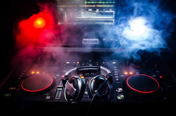 DJ Spinning, Mixing, and Scratching in a Night Club, Manos de dj ajustar varios controles de pista en la cubierta de dj, luces estroboscópicas y niebla, enfoque selectivo, de cerca. Dj Concepto de vida del club de música
 - Foto, Imagen