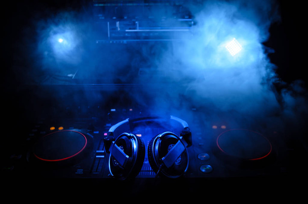 DJ Spinning, Mixing, e Scratching in a Night Club, Mãos de dj ajustar vários controles de pista no deck do dj, luzes estroboscópicas e nevoeiro, foco seletivo, close up. Dj Música conceito de vida clube
 - Foto, Imagem