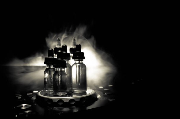 Koncept VAPE a Dj klubu. Kouřová mračna a vape láhve od DJ mixer zblízka. Světelné efekty. Užitečné jako nebo vape nebo klubu reklamu nebo vape pozadí. - Fotografie, Obrázek