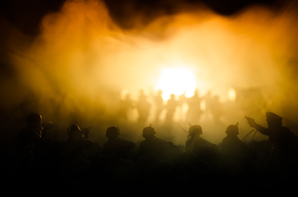 Sota-ajatus. Sotilaallinen siluetit taistelevat kohtaus sodan sumu taivaalla tausta, maailmansodan sotilaat siluetit alla pilvinen Skyline yöllä. Hyökkäyskohtaus. Panssaroidut ajoneuvot
 - Valokuva, kuva