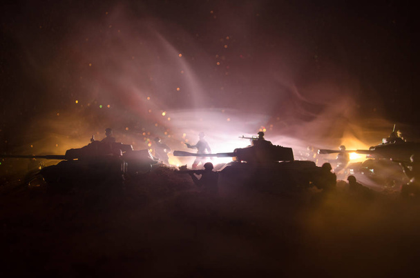 Concept van de oorlog. Militaire silhouetten vechten scène op oorlog mist hemel achtergrond, silhouetten van de Wereldoorlog soldaten onder bewolkte Skyline in de nacht. Aanval scène. Gepantserde voertuigen. - Foto, afbeelding