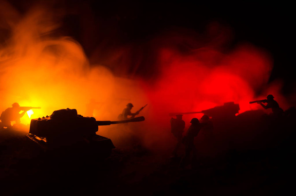 Concepto de guerra. Siluetas militares peleando escena en el fondo del cielo niebla de guerra, Soldados de la Guerra Mundial Siluetas debajo del horizonte nublado Por la noche. Escena de ataque. Vehículos blindados
. - Foto, imagen