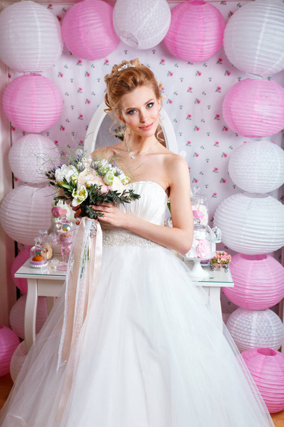 Beautiful bride with fashion wedding hairstyle and wedding dress posing in studio - Foto, afbeelding