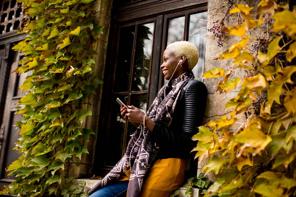 Молодая черная женщина со смартфоном
 - Фото, изображение