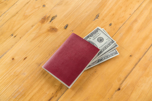 Blank passport with US dollars on wood table - Foto, afbeelding