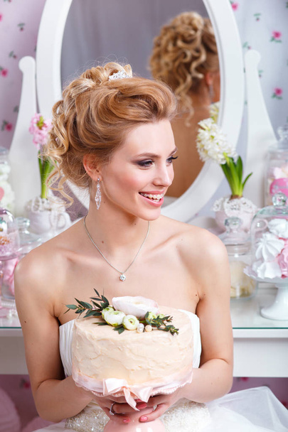 beautiful bride holding a wedding cake and smiling - 写真・画像