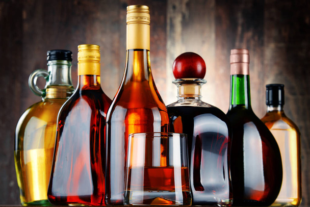 Glass and bottles of assorted alcoholic beverages - Photo, Image