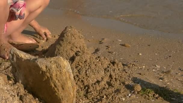 Kid bouwen een zandkasteel. - Video