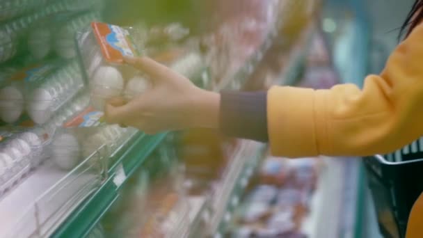 Woman chooses eggs in the supermarket - Filmati, video