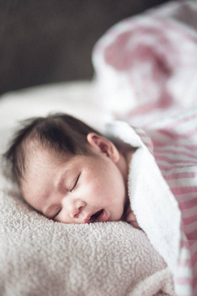 новорожденная симпатичная девочка спит на розовом заднем плане.
 - Фото, изображение
