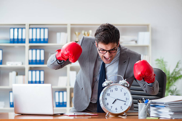 Сердитий бізнесмен з боксерськими рукавичками в концепції управління часом
 - Фото, зображення