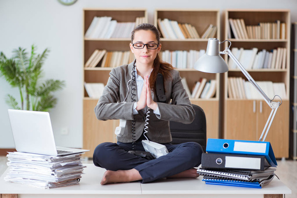 Деловая женщина медитирует в офисе - Фото, изображение