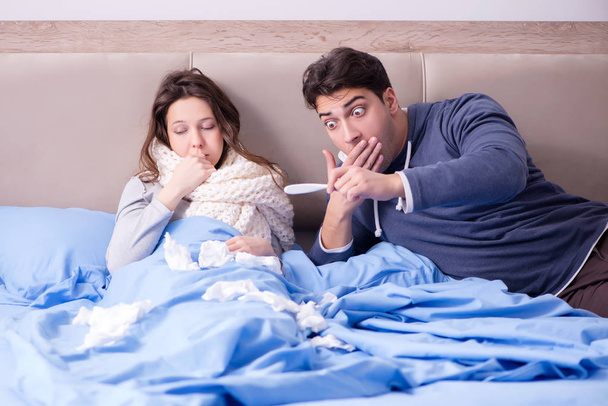 Wife caring for sick husband at home in bed - 写真・画像
