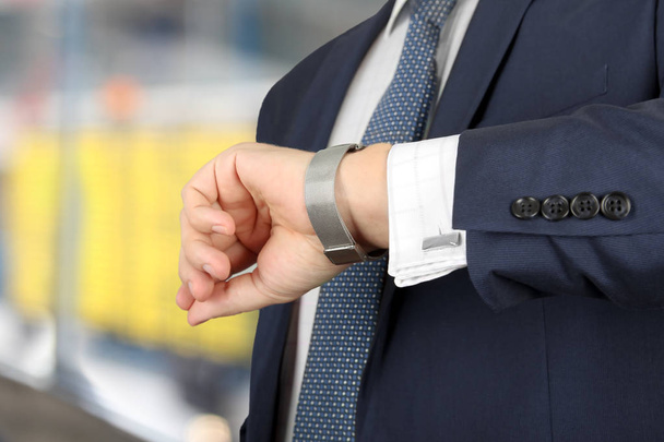  homme d'affaires vérifiant l'heure de sa montre à l'aéroport
 - Photo, image