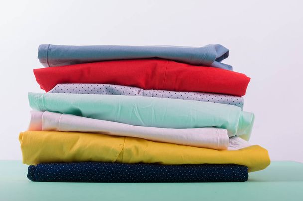 Folded colorful pants and jeans. Stack of bright female trousers. Close up. - Φωτογραφία, εικόνα