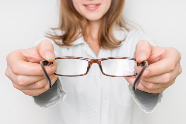 Optometrist giving new eyeglasses to patient - Фото, изображение