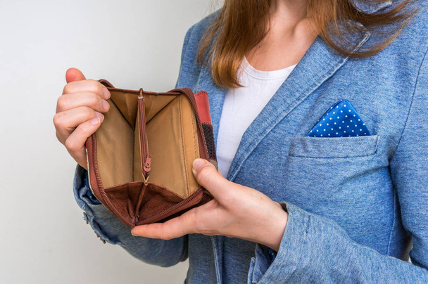 Mujer sosteniendo una cartera vacía, no tiene dinero
 - Foto, Imagen