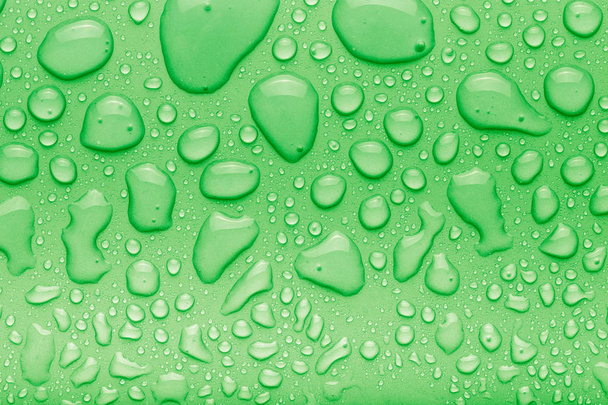 Drops of water on a color background. Green. Toned - Foto, imagen