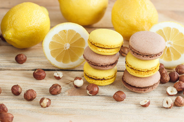 Yellow and brown french macarons with lemon and hazelnuts - Фото, зображення