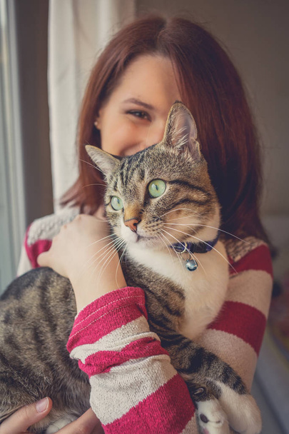 Домашние животные Care.Young женщина держит кошку дома
. - Фото, изображение