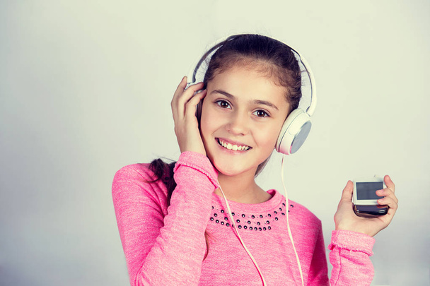 Smiling Little girl enjoying music in headphones  - Фото, изображение