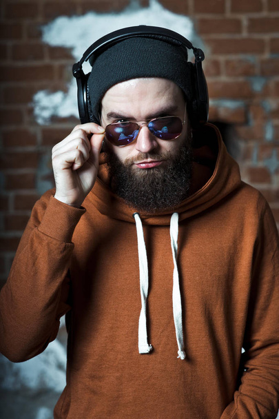 A bearded guy listens to music. The guy with glasses and headpho - Photo, Image
