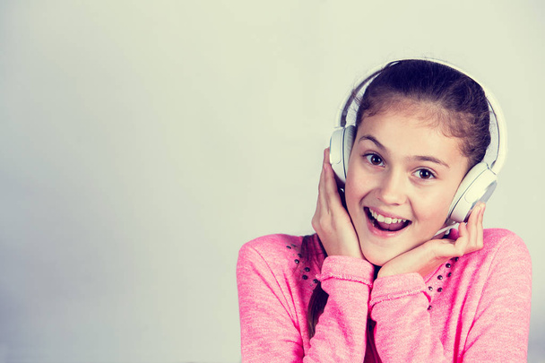 Little girl enjoying music in headphones at home relaxing - Zdjęcie, obraz