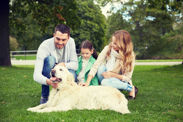 happy family with labrador retriever dog in park - 写真・画像
