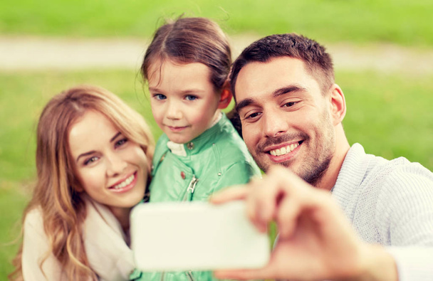 happy family taking selfie by smartphone outdoors - Фото, зображення