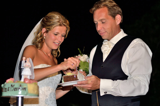 Жених и невеста едят свадебный торт
 - Фото, изображение