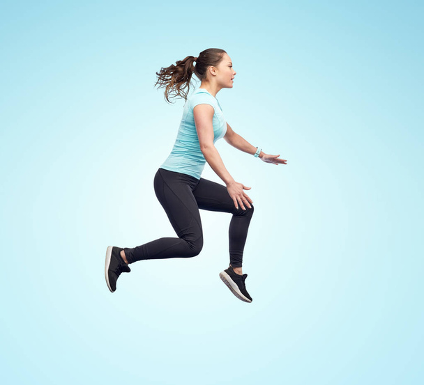 happy smiling sporty young woman jumping in air - Fotoğraf, Görsel