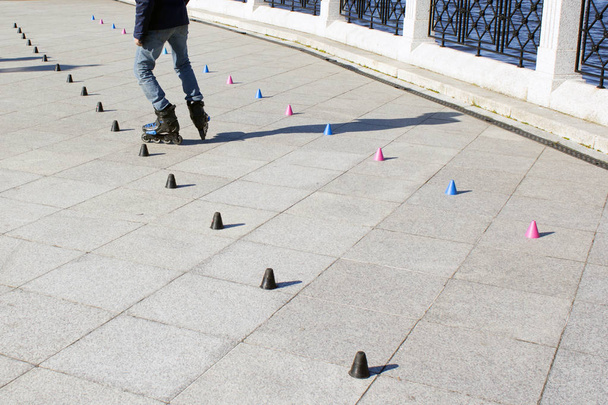 Roller skater practicing slalom along a line of cones - Zdjęcie, obraz