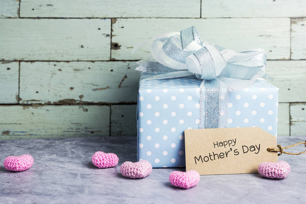 Boîte cadeau mignonne avec message heureux de la fête des mères sur étiquette en papier brun et coeur rose
 - Photo, image