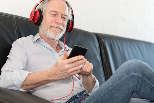 Współczesny człowiek dojrzały słuchania muzyki na telefon komórkowy - Zdjęcie, obraz