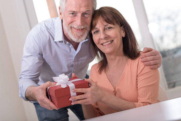 Mature couple with gift box - Фото, зображення