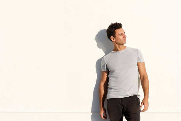 przystojny mężczyzna stojący t-shirt biały ścianę - Zdjęcie, obraz