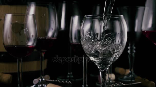 En la mesa hay copas llenas de vino, una copa de vino vacía está vertiendo vino. Movimiento lento
 - Imágenes, Vídeo