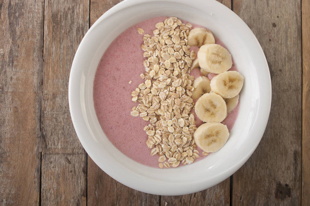Gezond muesli ontbijt met yoghurt, muesli, aardbeien en banaan - Foto, afbeelding